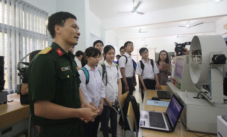 Cán bộ thuộc bộ môn Tên lửa đang giới thiệu một số khí tài trong phòng nghiên cứu tên lửa cho các học sinh tham quan