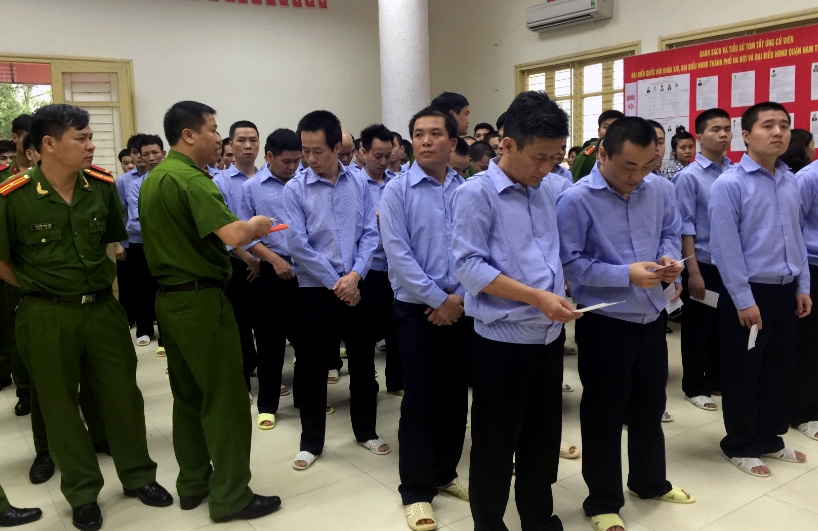 Thành viên tổ bầu cử phát thẻ cử tri cho các can phạm.