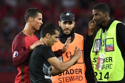 Một CĐV Bồ Đào Nha vào sân để chụp ảnh với Ronaldo.