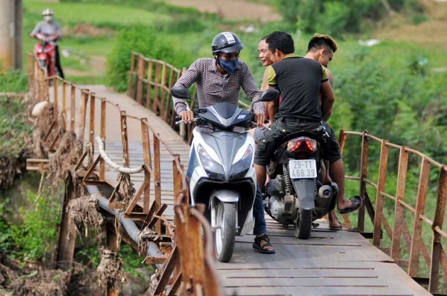  Hai chiếc xe máy khó khăn di chuyển từng chút một qua cầu. 