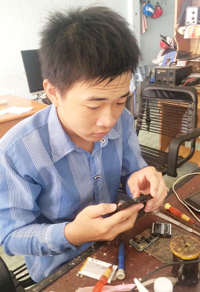 Anh Ca học sửa điện thoại sau khi được minh oan tội Cướp tài sản. Ảnh: Phúc Hưng
