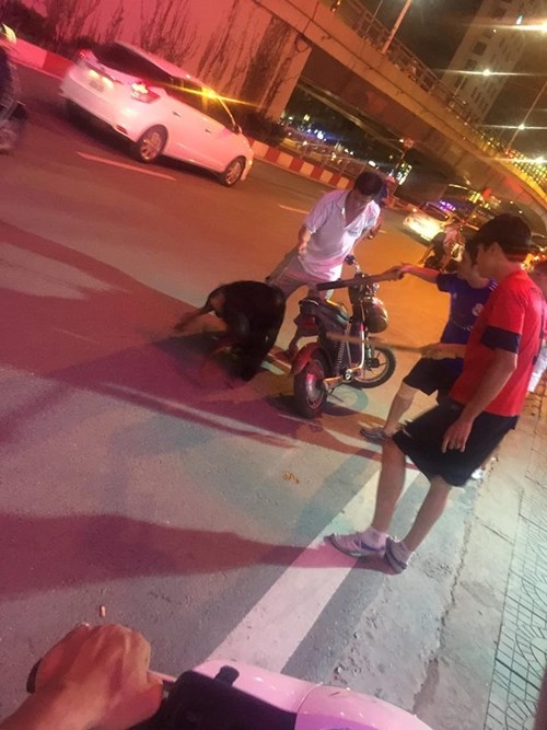 Hình ảnh chủ chú chó doberman cùng người dân xua để tách hai chú chó khi cắn nhau