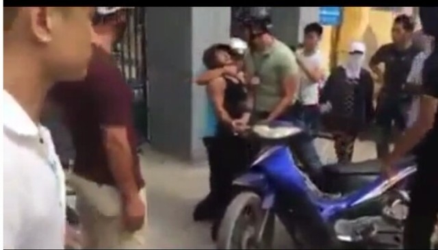 Thanh niên mậc áo màu xanh ghì cổ người vi phạm, xưng hô mày tao với dân ( ảnh cắt từ clip)