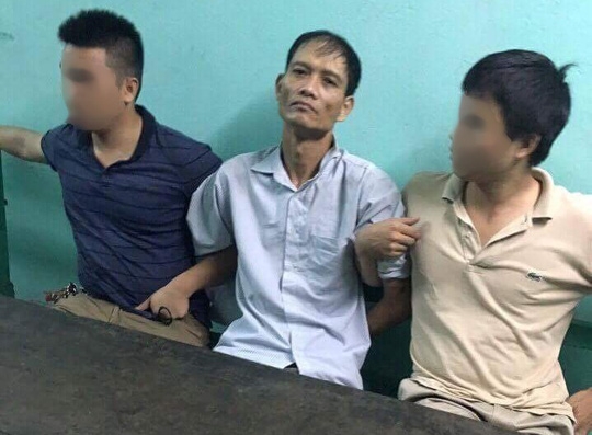  Nghi phạm Doãn Trung Dũng (giữa) khi bị bắt giữ 