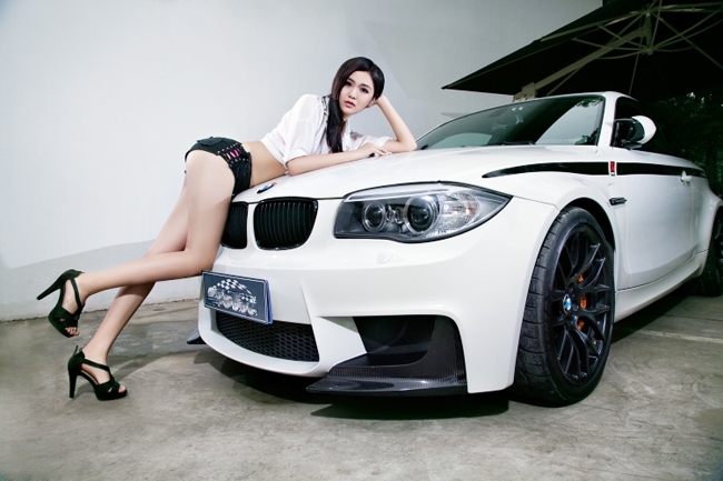 Chiếc BMW M1 màu trắng sang trọng cũng không thể khiến người xem bận tâm, bởi bên cạnh nó là hotgirl xinh đẹp và sexy đang tạo dáng bên xe.