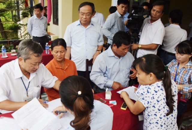 Ông Nguyễn Văn Cao, Chủ tịch UBND tỉnh Thừa Thiên Huế (đứng, đeo kính) đi kiểm tra công tác chi trả tiền bồi thường sự cố Formosa cho người dân (ảnh: Cổng thông tin UBND tỉnh Thừa Thiên Huế)