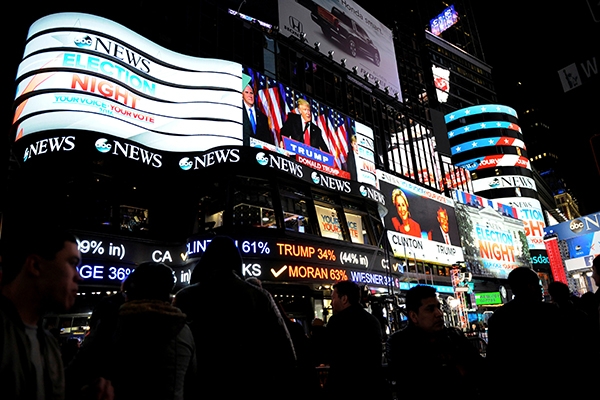 People watch as U.S. president-elect Donald Trump is displayed speaking, in Times Square in New York, U.S., November 9, 2016. REUTERS/Mark Kauzlarich