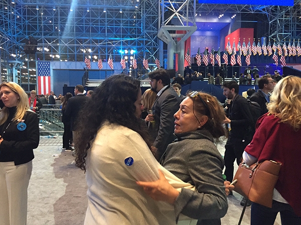 Some people are standing around hugging and crying after Podesta's announcement at Javitz