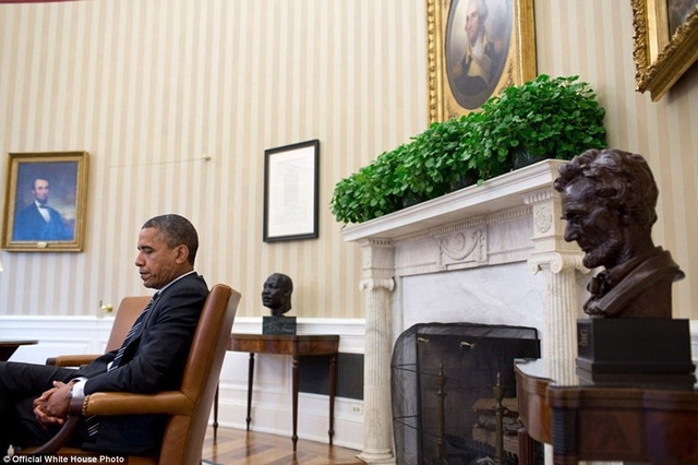 Một khoảnh khắc suy tư của Tổng thống Obama bên bàn làm việc trong Phòng bầu dục.