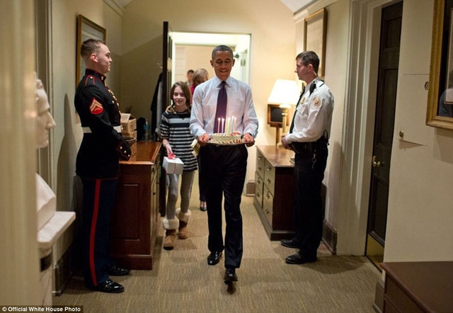 Tổng thống Obama cùng con gái của Chánh Văn phòng Denis McDonough mang một chiếc bánh kem để làm ông bất ngờ trong ngày sinh nhật.