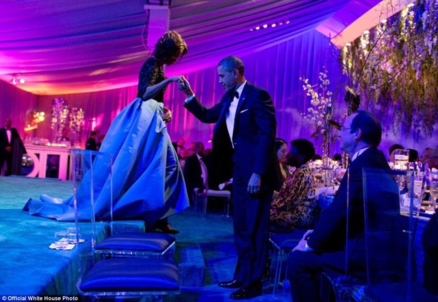 Tổng thống Obama giúp vợ của mình rời khỏi sân khấu sau khi bà nói lời cám ơn các đầu bếp của Nhà Trắng đã chuẩn bị buổi tiệc để tiếp đón Tổng thống Pháp Francois Hollande trong chuyến công du đến Mỹ vào năm 2014.