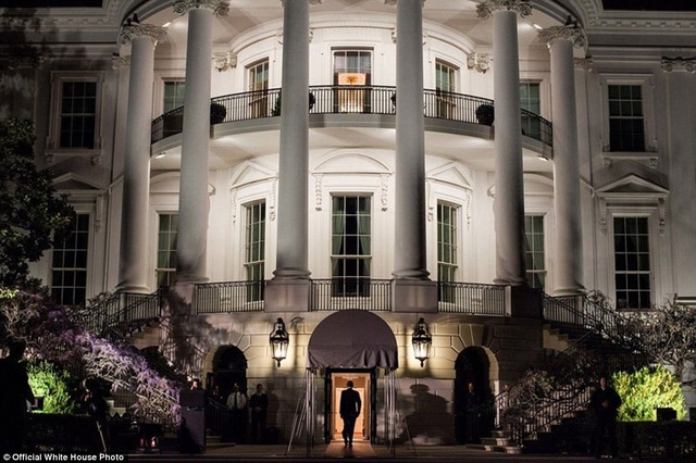 Tổng thống Obama bước vào Nhà Trắng sau một ngày làm việc ở bên ngoài.