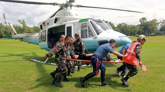  Một nhân viên an ninh được chuyển bằng trực thăng tới bệnh viện sau vụ nổ bom. Ảnh: REUTERS 