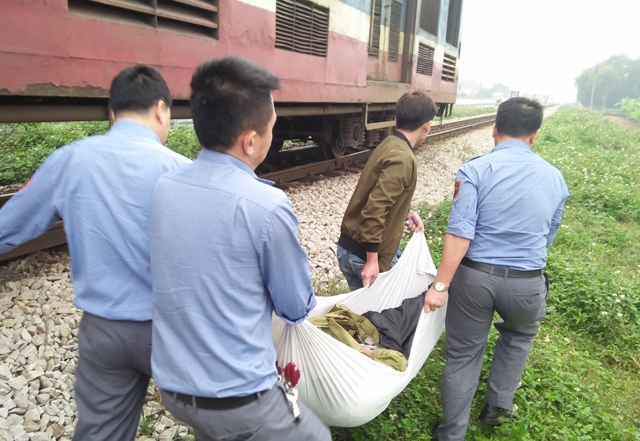 Nhân viên đường sắt và người dân địa phương đưa người bị nạn ra xe cứu thương.