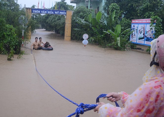 Thanh niên dùng phao để đưa các cháu ở trường mầm non ra ngoài /// ẢNH: NGỌC ANH