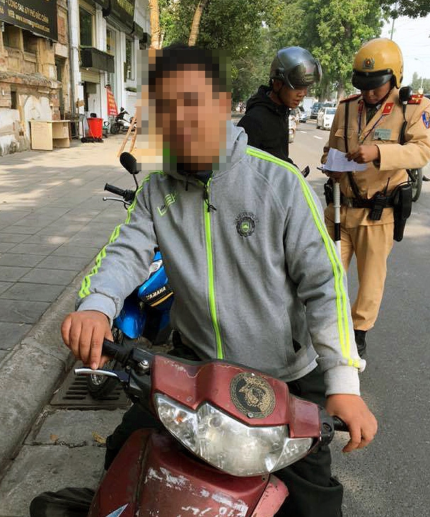 Nam thanh niên điều khiển xe máy không đội mũ bảo hiểm, tự nhận là công an khi bị CSGT kiểm tra.