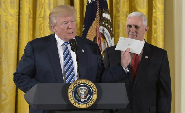  Tân Tổng thống Mỹ Donald Trump giơ bức thư của người tiền nhiệm Barack Obama trong lễ tuyên thệ tại Nhà Trắng ngày 22/1. (Ảnh: AFP) 