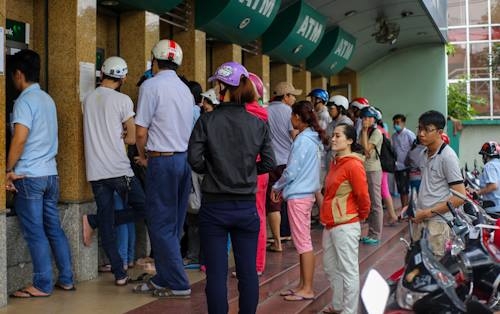  Tại các khu công nghiệp Linh Xuân (quận Thủ Đức), khu chế xuất Tân Thuận (quận 7), hàng trăm công nhân xếp hàng dài trước trụ ATM để tút tiền về Tết. 