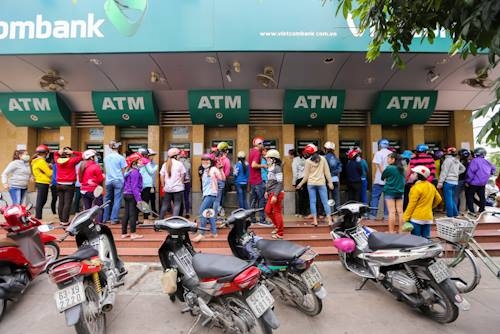 Dòng người tập trung trước trụ ATM ở khu chế xuất Tân Thuận, quận 7 chờ để rút tiền.