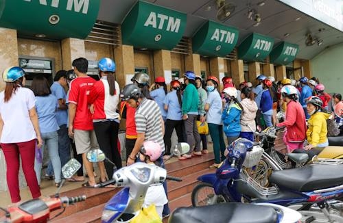 Càng về chiều, dòng người chờ rút ATM càng kéo dài thêm.