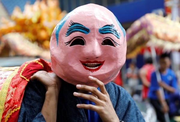 A resident wears a mask on the Lunar New Year eve in Manila's Chinatown, the Philippines January 27, 2017. REUTERS/Erik De Castro