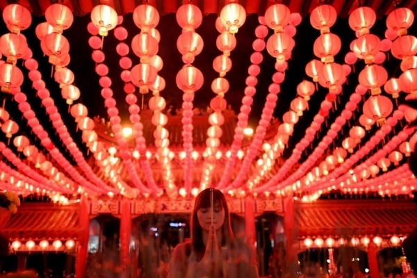 An Ethnic Malaysian-Chinese devotee burns joss-sticks at the Thean Hou temple decorated with red lanterns in Kuala Lumpur on January 27, 2017 on the eve of the Lunar New Year. The Lunar New Year will mark the start of the Year of the Rooster on January 28.