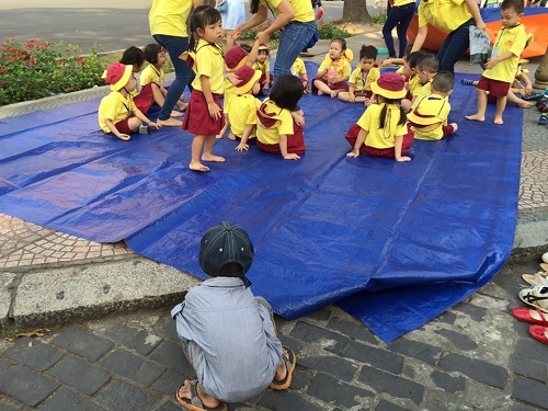 Bức ảnh đáng yêu nhất ngày: Cậu bé lượm ve chai vô tư xếp dép cho các bạn dã ngoại - Ảnh 3.