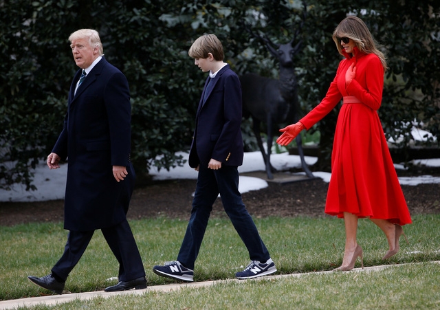 Đệ nhất phu nhân Melania gây ấn tượng với bộ trang phục màu đỏ lịch lãm và đẹp mắt trong khi Barron cũng khiến nhiều người bất ngờ vì sự cao lớn của cậu bé này. Là cựu siêu mẫu nổi tiếng gốc Slovenia, bà Melania từng nhận được nhiều lời khen về gu thời trang tinh tế và thời thượng. Trong ảnh: Gia đình Tổng thống Trump băng qua bãi cỏ tại Nhà Trắng.