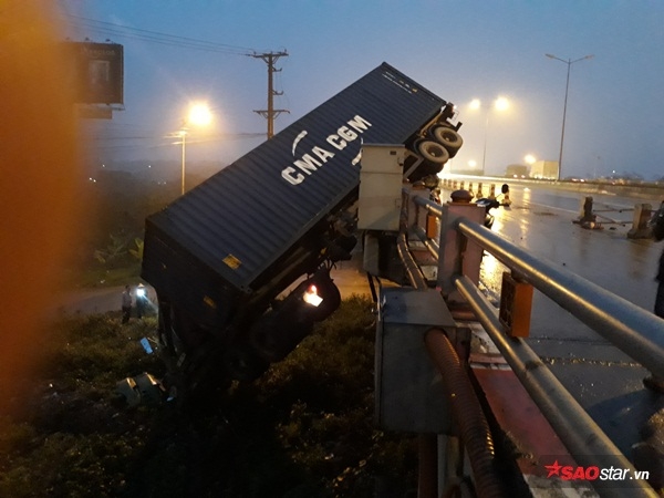 Xe container “cắm đầu” qua lan can cầu.