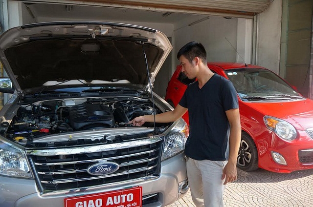 Nhân viên của showroom đang hướng dẫn các bước chọn mua xe cũ.