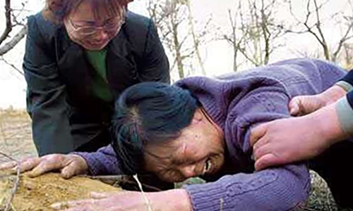 Mẹ của Nhiếp Thụ Bân đau khổ khóc bên mộ con trai sau khi Trung Quốc xác định đây là vụ án oan. Ảnh: SCMP