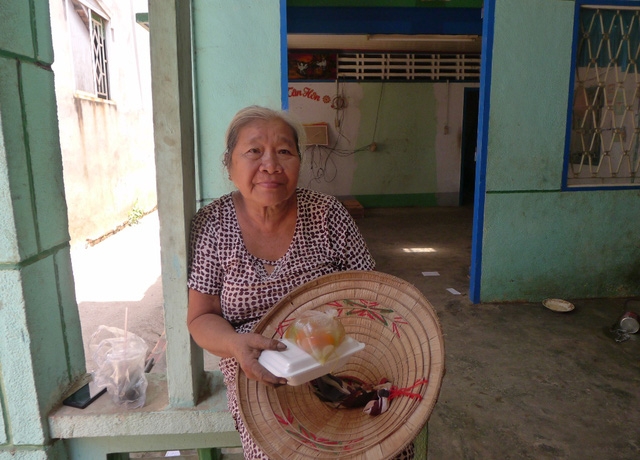 Bà Nguyễn Thị Điệp cầm hộp cơm trên tay nhưng chưa thể nuốt nổi vì còn lo chỗ ăn, chỗ ở sắp tới