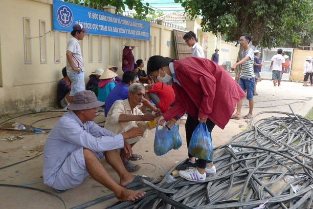Các em học sinh phục vụ nước uống miễn phí cho người dân