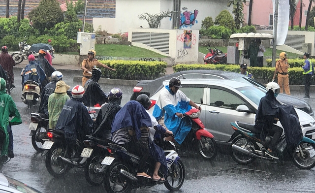 CSGT và lực lượng TNXP, nhân viên đơn vị thi công dầm dưới cơn mưa tầm tã để điều tiết...