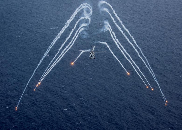  Một trực thăng MH-60R Sea Hawk của Hải quân Mỹ bắn pháo sáng khi tập trận gần tàu sân bay USS Carl Vinson ở vùng biển Philippines hôm 24/4. 
