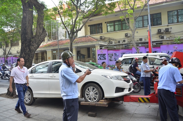Lực lượng Trật tự đô thị quận 1 vẫn thường xuyên ra quân xử lý khi đoàn liên ngành ngừng ra quân (trong ảnh là Đội trật tự đô thị quận 1 xử lý chiếc ô tô đậu trên vỉa hè đường Đồng Khởi trưa 19/5)