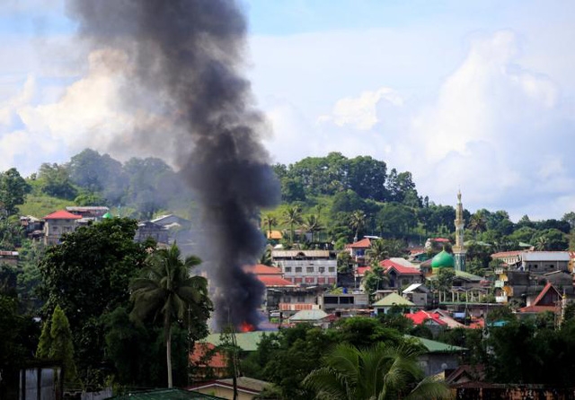 Khói bốc lên từ một căn nhà bị phóng hỏa ở Marawi (Ảnh: Reuters)
