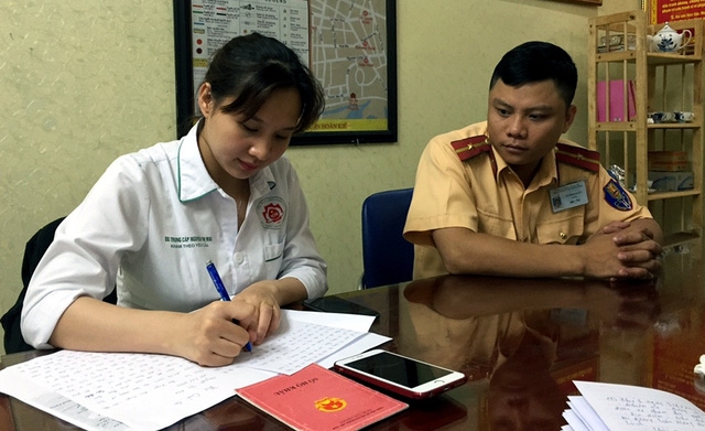  Thiếu úy Quân hướng dẫn chị Mai chứng minh chiếc điện thoại là của mình, làm thủ tục để nhận lại. 