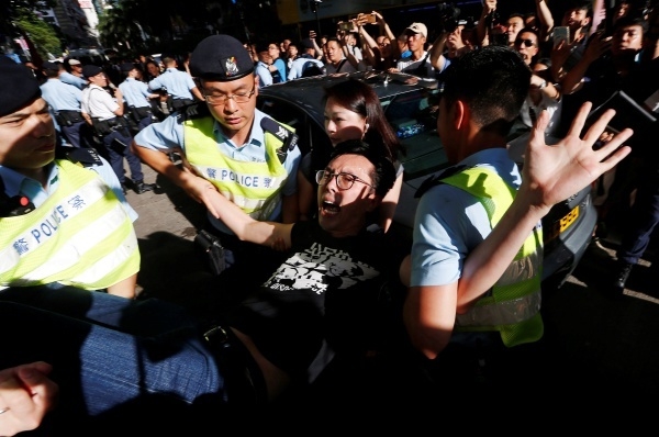 Avery Ng is detained by police as he takes part in a protest demanding the release of Chinese Nobel rights activist Liu Xiaobo, during Chinese President Xi Jinping's visit in Hong Kong, China
