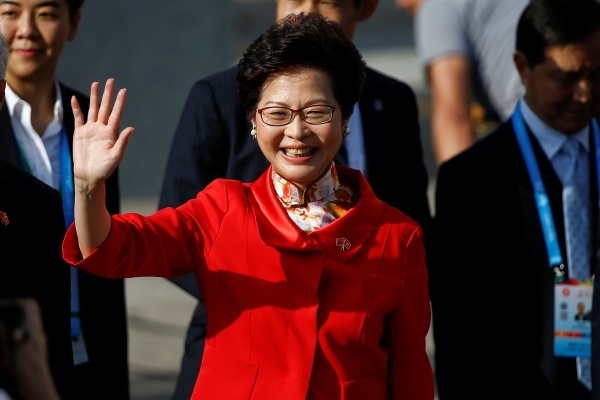 Bà Carrie Lam (thứ ba, từ trái sang), người sắp nhậm chức trưởng đặc khu, vẫy tay tại lễ thượng cờ. Ảnh: Reuters.