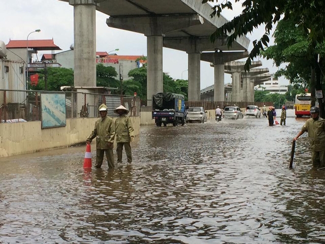 Công nhân phải đứng giữa đường để cảnh báo cho người tham gia giao thông không đi vào chỗ nguy hiểm.