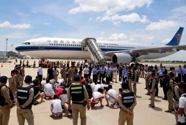 Các nghi phạm Trung Quốc bị Campuchia trục xuất trước khi lên máy bay về nước (Ảnh: Reuters)
