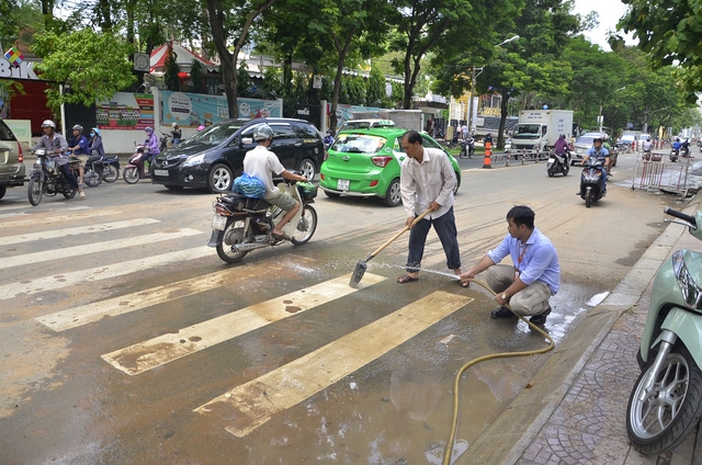 Đại diện đơn vị thi công tiến hành xả nước để chùi rửa mặt đường sau khi bị lập biên bản