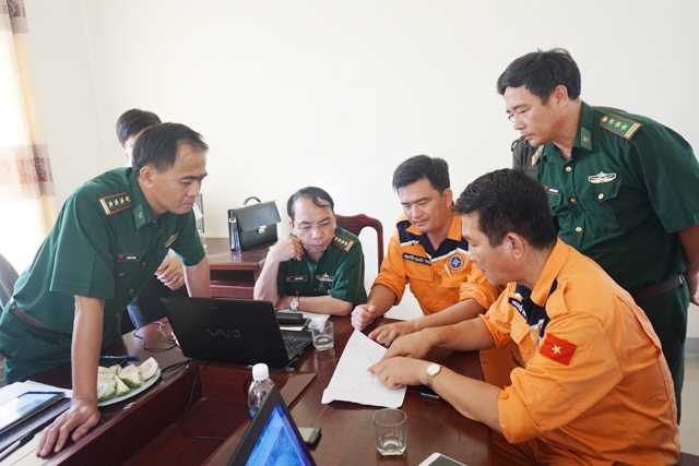 Ông Nguyễn Văn Tính (áo vàng ngoài cùng) bàn phương án với Sở chỉ huy tìm kiếm cứu nạn phía trước sẽ thực hiện trong ngày mai