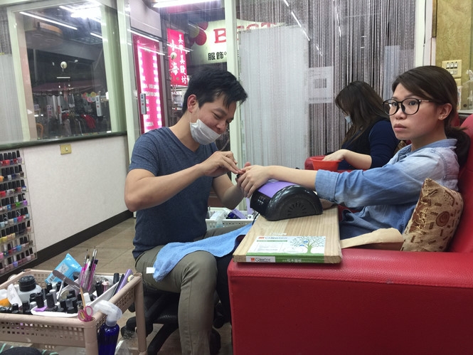 Anh Sang đang cần mẫn làm móng tay cho khách  /// Ảnh: Lucy Nguyễn